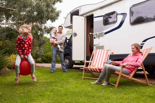 Family enjoying camping holiday with RV